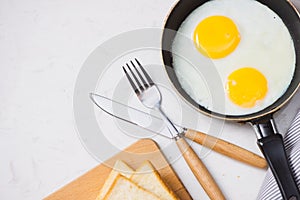 Eating in the process, fried eggs in a frying pan, toast and or