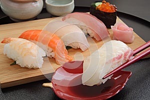 Eating Sea Bream Sushi with Chopsticks, Japanese Food photo