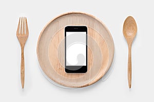 Eating smartphone on set of fork,spoon and dish wood isolated.