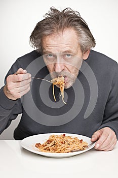 Eating spaghetti with minced pork and beef meat, tomato sauce and cheese