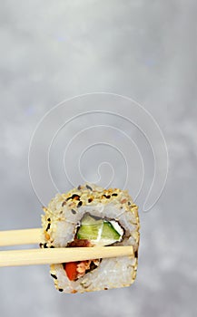Eating sushi with chopsticks close-up, japanese food sushi roll in restaurant