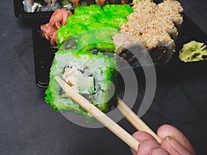 Eating sushi with chopsticks, selective focus