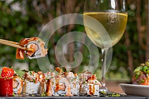 Eating sushi, still life, eating out concept.. Young woman in restaurant or at home eats Japanese sushi rolls set. Close on sushi