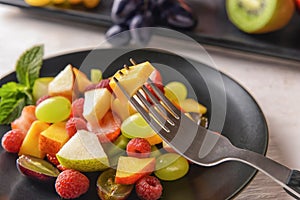 Eating of tasty fruit salad, closeup