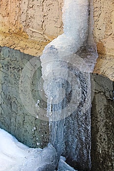 An eavestrough covered in ice and spring runoff water photo