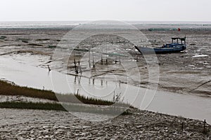 After the ebb, the boat ran aground on the tidal flat river of mud,