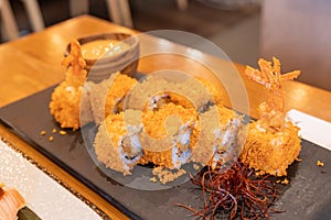 Ebi Tempura Maki Fried Prawn or shrimp Sushi roll on slate. Japanese traditional fusion food style, restaurant menu.