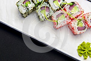 Ebiko black caviar adn red caviar sushi rolls - japanese food style. Served on a white plate over black background