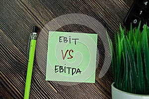 Ebit Vs Ebitda write on sticky notes isolated on Wooden Table