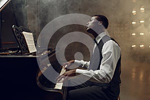 Ebony grand piano player playing on the stage