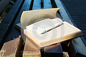 Ebook laying on a book on the bench. new technology concept