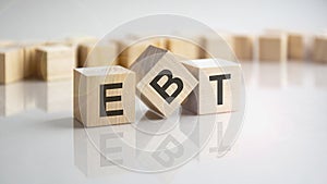 EBT - Earnings Before Taxes shot form on wooden block