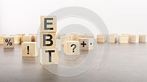 ebt text as a symbol on cube wooden blocks. many wooden blocks with symbol in the background