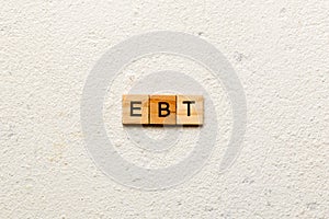 EBT word written on wood block. Abbreviation Earnings Before Taxes text on cement table for your desing, concept
