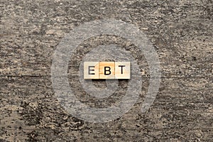 EBT word written on wood block. Abbreviation Earnings Before Taxes text on cement table for your desing, concept