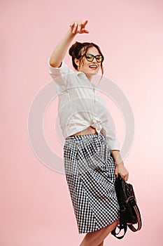 Eccentric student lady making rap gestures. Over pink background.