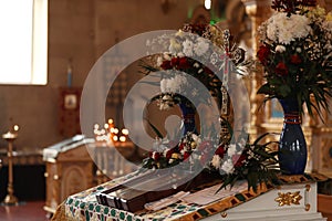 Ecclesiastical icon, cross and flowers on altar in church. Baptism ceremony