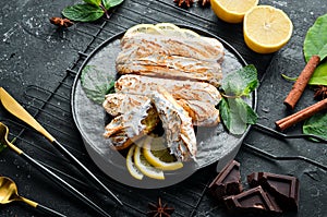 Eclair with lemon cream. Lemon dessert on a black stone plate. Top view. Rustic style