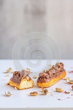 Eclair with vanilla cream, peanuts and chocolate.