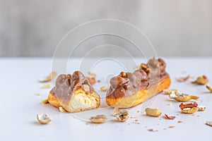 Eclair with vanilla cream, peanuts and chocolate.