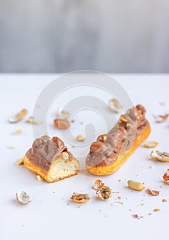 Eclair with vanilla cream, peanuts and chocolate.