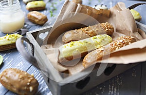 Eclairs with chocolate and whipped cream on dark background