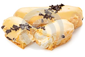 eclairs with filled vanilla cream and covered with chocolate isolated on white background