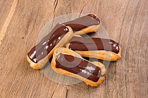 Eclairs traditional homemade French cuisine with chocolate on wo