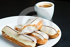 Eclairs with white icing on a plate