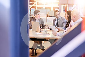 Eclectic group of four business professionals conducting a meeting