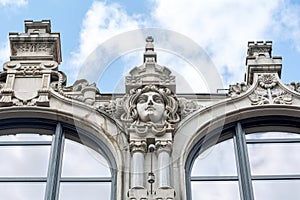 Eclecticism in architecture, head sculpture classic antique building exterior detail up close, old tenement house front view