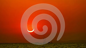 Eclipses and diamond ring phenomenon as the sun sets over sea