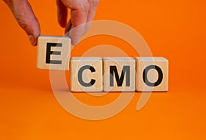 ECMO symbol. Concept words `ECMO, Extra Corporeal Membrane Oxygenation` on wooden cubes on a beautiful orange background. Male photo