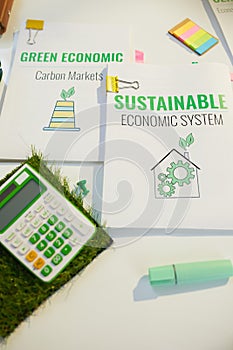 eco aware business. calculator and documents at table