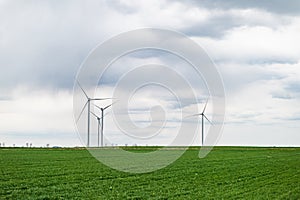 Eco banner or header image of three wind turbines of a wind farm, producing renewable energy. Clean green alternative