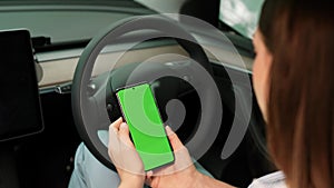 Eco-conscious couple on driver seat holding blank copyspace screen phone. Exalt