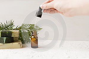 Eco cosmetic products for skin, body. A woman& x27;s hand holds a bottle of natural essentia next to soap and other