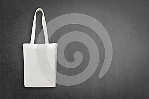 Eco cotton tote bag mock up white shopping fabric cloth sack with handle on blackboard background for mockup design backdrop