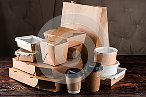 Eco craft paper tableware. Paper cups, dishes, bag, fast food containers, box for delivery food on wooden background