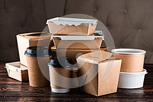 Eco craft paper tableware. Paper cups, dishes, bag, fast food containers, box for delivery food on wooden background