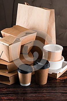 Eco craft paper tableware. Paper cups, dishes, bag, fast food containers, box for delivery food on wooden background