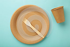 Eco craft paper tableware. Paper cups, dishes, bag, fast food containers and wooden cutlery on blue background. Zero waste.