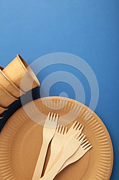 Eco craft paper tableware. Paper cups, dishes, bag, fast food containers and wooden cutlery on blue background. Zero waste.