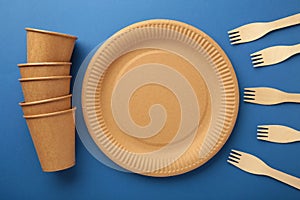 Eco craft paper tableware. Paper cups, dishes, bag, fast food containers and wooden cutlery on dark blue background. Zero waste.