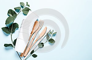 Eco dishes. Paper cups, wooden fork, spoon, knife, tube, on a blue background