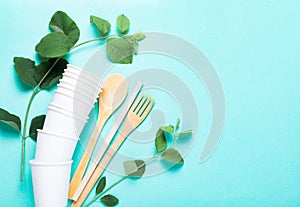 Eco dishes. Paper cups, wooden fork, spoon, knife, tube, on a blue background