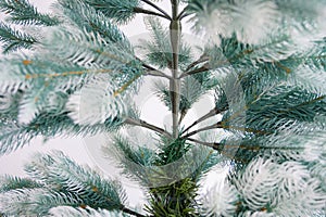 Eco-friendly artificial tree for the new year. A bare Christmas tree without decorations is standing against a white