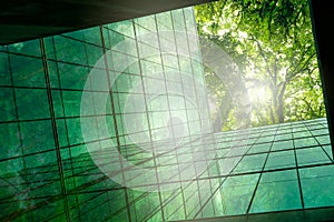 Eco-friendly building in modern city. Sustainable glass office building with trees for reducing CO2. Green architecture. Building