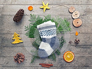 Eco Friendly Christmas flat lay. Winter holiday in Hygge style. Knitted childs socks, fir branches, handmade toy snowman and craft