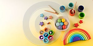 Eco-friendly colored wooden educational toys according to the Montessori method on a yellow background. Copy space.